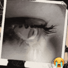 a close up of a woman 's eye with a crying smiley face next to it