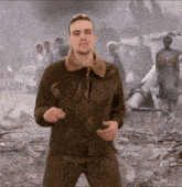 a man in a military jacket is standing in front of a group of people