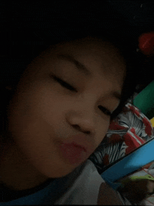 a young boy is making a funny face while laying on a bed