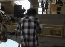 a man in a plaid shirt is standing in front of a sign that says philo 2 .