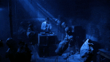 a man in a white shirt and tie is standing in a dark room