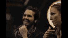 a man and a woman are sitting next to each other and laughing .