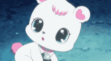 a white teddy bear with a pink heart on its ear is looking at the camera .