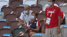 a man wearing a red canada shirt stands in a stadium