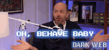 a man in front of a microphone with the words oh behave baby dark web above him