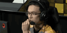 a man wearing glasses and headphones is sitting in a chair .