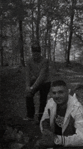 two men posing for a picture with one wearing a gd hat