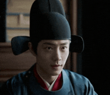 a man wearing a black hat and a blue shirt