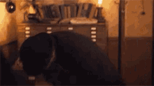 a man is kneeling down in a dark room with a lamp .