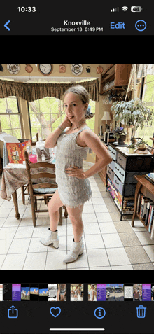 a phone screen shows a photo of a girl in a white dress and white boots
