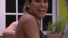 a woman is standing in front of a window smiling .
