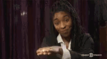 a woman in a suit and tie is blowing a kiss while wearing headphones .