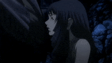 a woman with long dark hair is standing in the dark with her eyes closed