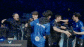 a group of people are standing in a dark room and one of them is wearing a blue shirt that says shifter .