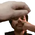a man with a beard is being slapped on the forehead by a hand .