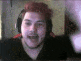 a man with red hair is wearing headphones and a beard