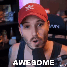 a man wearing an adidas hat is talking into a microphone and says awesome