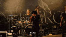 a man stands in front of a drum set that says ' tama ' on it