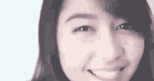 a close up of a woman 's face smiling at the camera .
