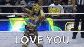 a woman in a wrestling ring with a sign that says `` love you '' .
