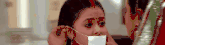 a woman is covering a woman 's mouth with a piece of paper .