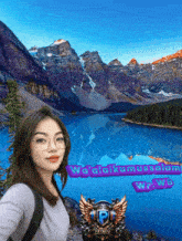 a woman is taking a selfie in front of a lake with mountains in the background and a purple sticker that says we click