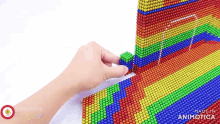 a person is playing with a rainbow colored toy made of magnets
