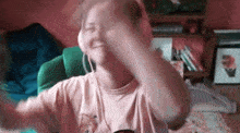 a woman wearing headphones and a pink shirt is smiling and dancing