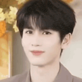 a close up of a young man 's face looking at the camera .