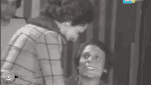 a black and white photo of a man and a woman with a play button on the bottom right