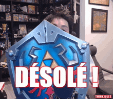 a man holding a shield with the word desole written on it