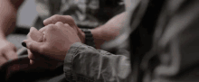 a close up of a person holding another person 's hand while wearing a watch .