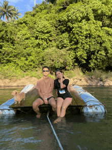 a man and a woman are sitting on a boat in the water with a dog