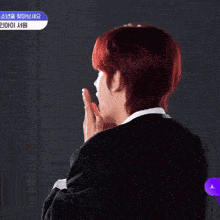 a man with red hair is clapping in front of a sign that says ' i 'm sorry '