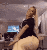 a woman in a black shirt is dancing in a living room .