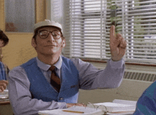 a man wearing glasses and a hat is giving a high five