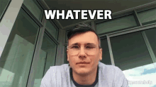 a man wearing glasses and a gray shirt says whatever