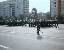 a man walking down a street with a broom