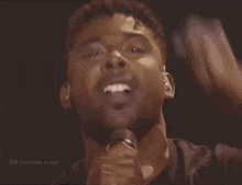 a close up of a man singing into a microphone with the word sweden on the bottom