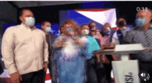a group of people wearing face masks are standing around a podium that says fsl