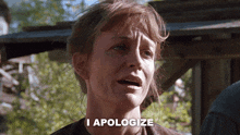 a woman says i apologize in front of a wooden building