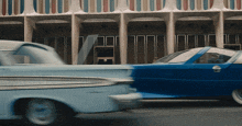 a blue car is parked in front of a building with a striped facade