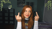 a woman with red hair is giving the middle finger while wearing a black shirt that says venom