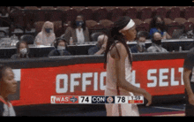 a basketball game is being played in front of an official selt sign