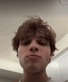 a close up of a young man 's face making a funny face