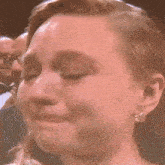 a close up of a woman 's face with a tear running down her face