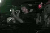 a blurry picture of a person standing in a dark room with a red light in the background