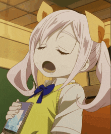 a girl with pigtails is yawning while holding a book that says tokyo