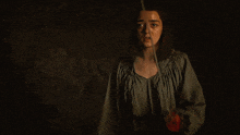 a candle is lit in a dark room with a blurry person behind it