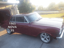 a 1965 nova ss is parked in the driveway
